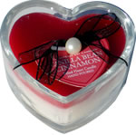 Red and white candle in small heart-shaped glass cylinder