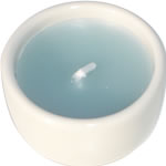 Single blue candle in white ceramic cup