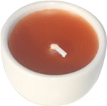 Single orange candle in white ceramic cup 